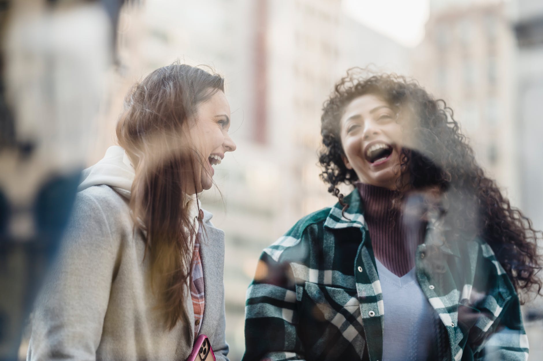 through glass of laughing diverse women