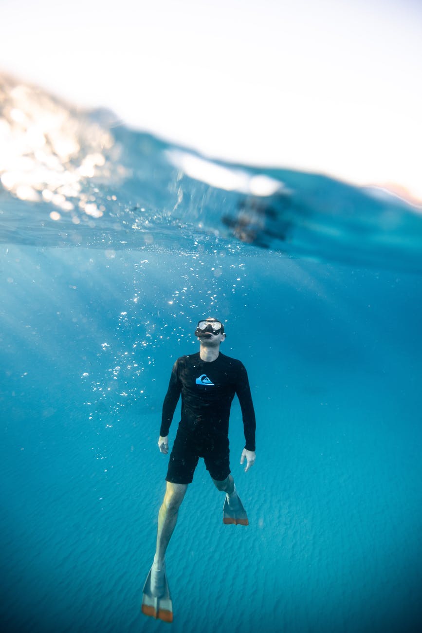 split level photography of man underwater