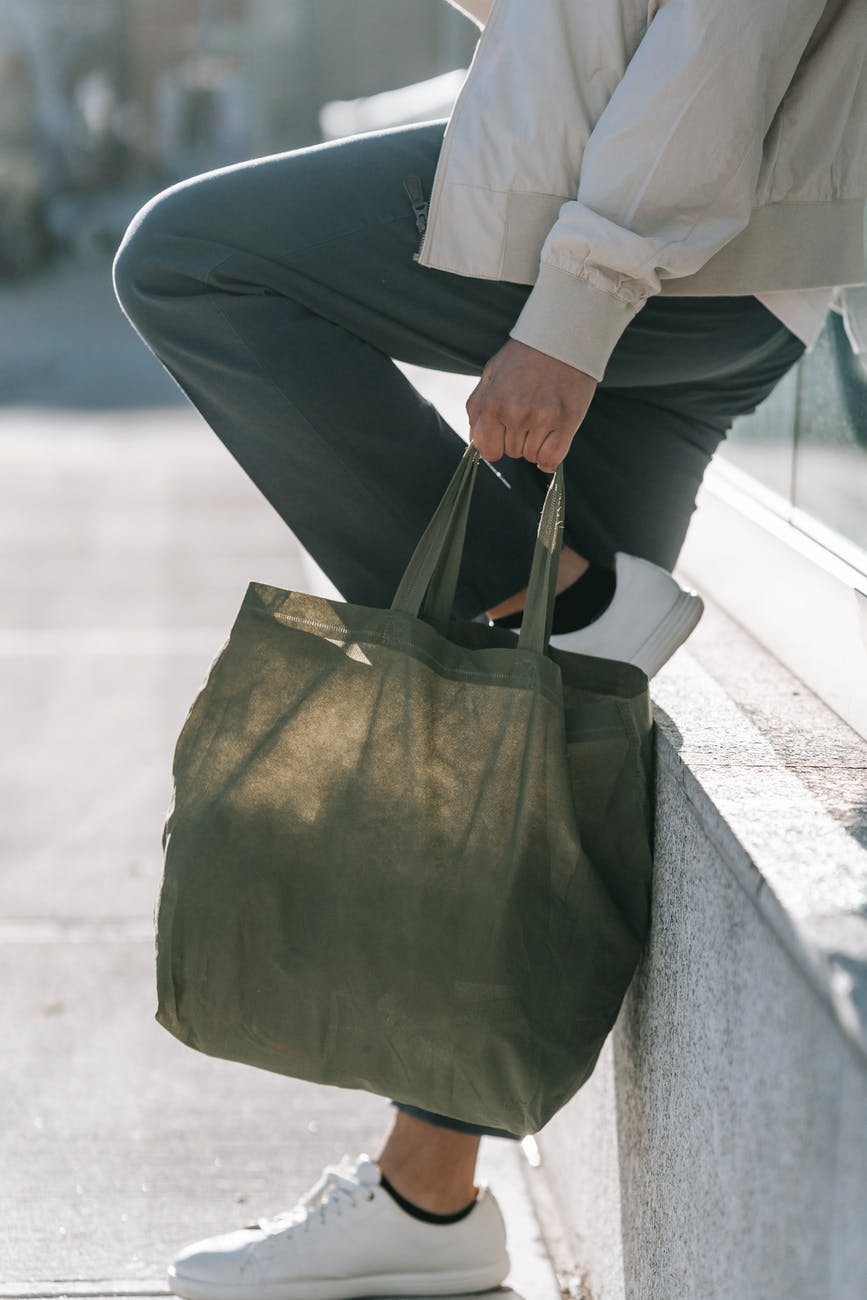 crop stylish man with zero waste bag on city street