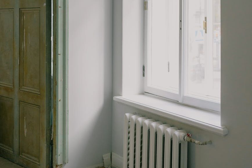 shiny window above radiator in new apartment