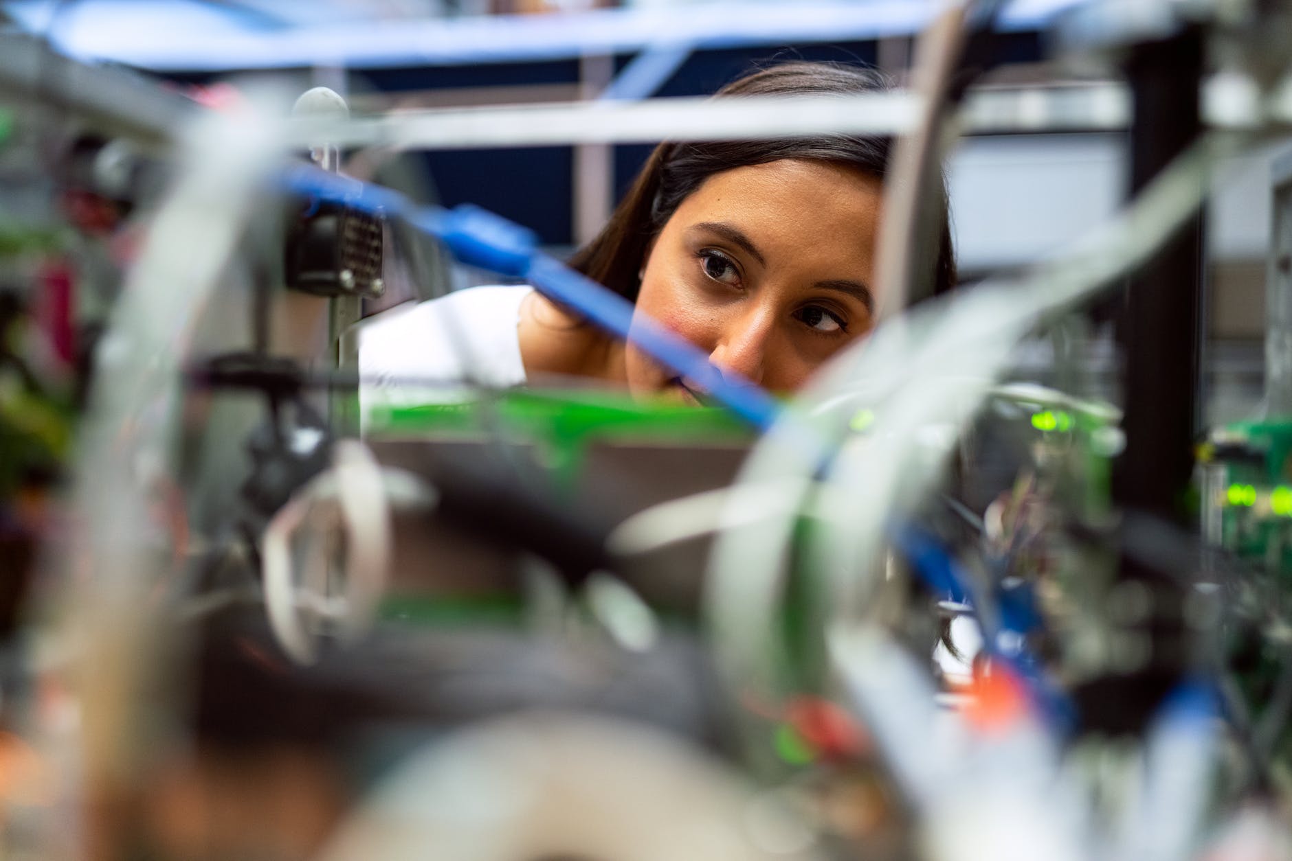 photo of female engineer looking through wires